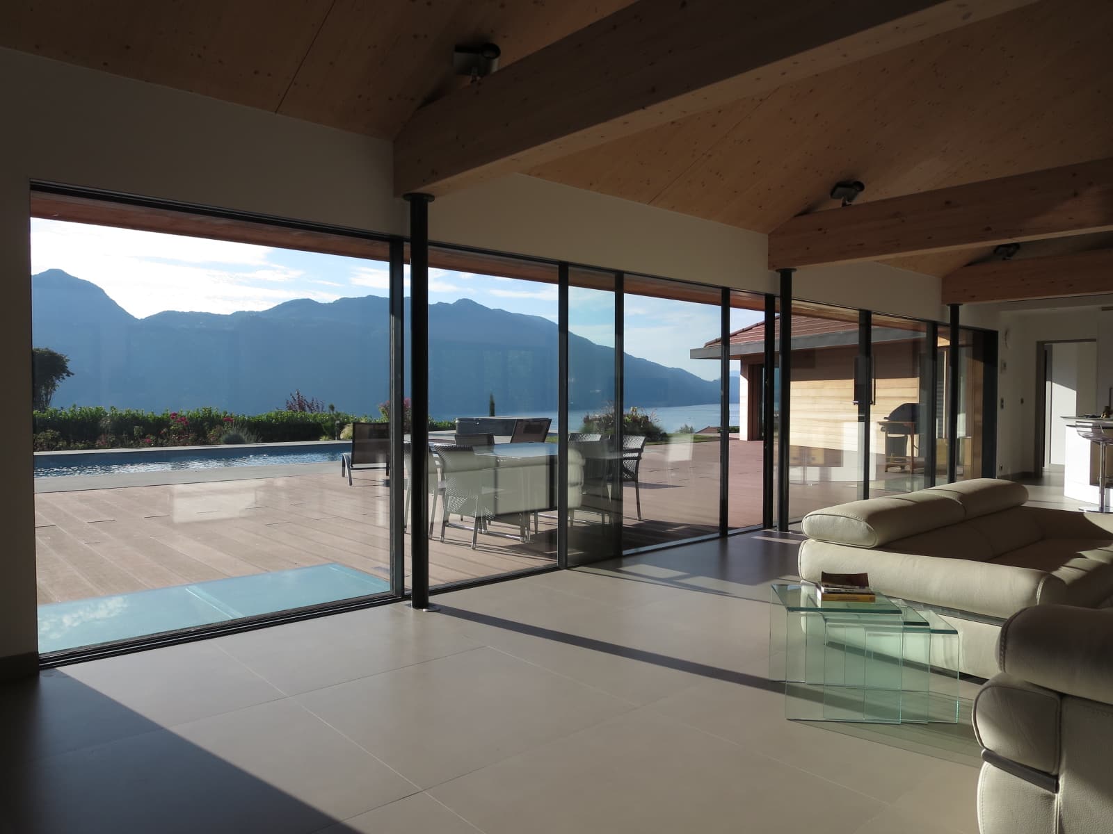 autre vue du salon sur piscine et lac et grande baie vitrée